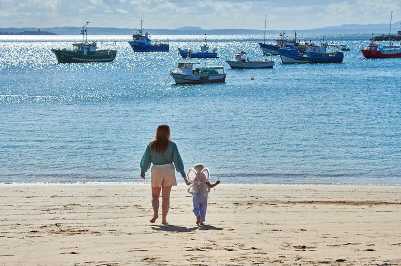 CASCAIS, PORTUGAL - MAY 01: A woman and a little girl walk toward the waterline in Praia dos Pescadores on the day it ends the state of emergency during the COVID-19 Coronavirus pandemic on May 01, 2021 in Cascais, Portugal. The country has reverted to state of "calamity", opened its borders with Spain and reestablished among different measures the possibility of practicing outdoors sports. The epidemiological bulletin released today by the Directorate General of Health (DGS) reported 470 new cases of COVID-19 and one more death in the last 24 hours. In total, Portugal register 836,947 infections, 16,976 deaths and 796,477 recoveries. (Photo by Horacio Villalobos#Corbis/Corbis via Getty Images)