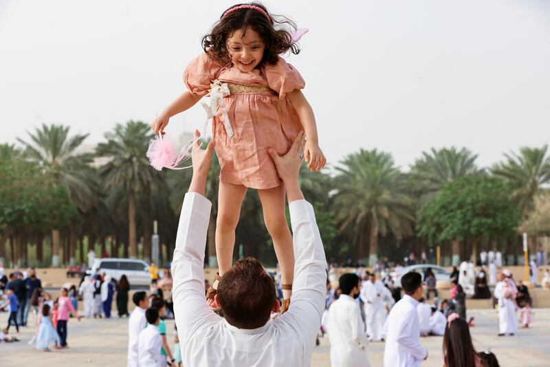 A Saudi man holds his daughter during Eid Al Fitr celebrations at the King Abdul Aziz Mosque, in Riyadh, in 2022. Reuters