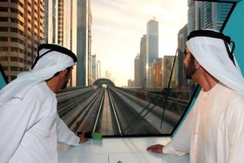 Sheikh Mohammed, right, rides the Metro after touring the new Concourse 3 terminal at Dubai International Airport. Wam