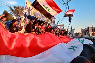 Anti-government protesters chant slogans while holding national flags during a demonstration against the newly appointed Prime Minister designate Mohammed Allawi, Monday, Feb. 3, 2020, in Tahrir Square, Baghdad, Iraq. AP