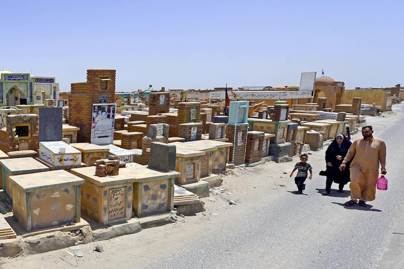 Shiite muslims visit the graves of their relatives at Wadi al-salam (Valley of Peace) cemetery on the first day of the Eid al-Fitr holiday marking the end of the Muslim holy month of Ramadan, despite COVID-19 curfew in the Iraqi Shiite holy city of Najaf on May 25, 2020. (Photo by Haidar HAMDANI / AFP)