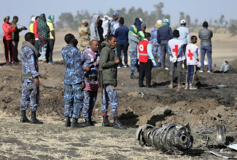 Ethiopian Federal policemen stand near engine parts at the scene. Reuters