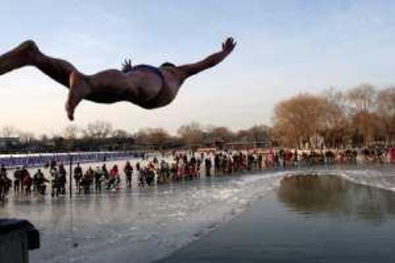 ** ADD MORE INFORMATION ** A swimmer leaps towards the icy water at Houhai Lake in Beijing, China, Saturday, Jan. 12, 2008. The lake is popular for tourists throughout the year but when the winter season arrives it becomes one of Beijing's favorite spots for winter time recreation. (AP Photo)