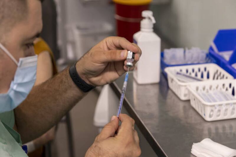A health worker in Israel prepares a booster dose of the Pfizer-BioNTech Covid-19 vaccine. BioNTech has raised its forecast for this year’s Covid-19 vaccine sales to $18.7 billion. Bloomberg via Getty Images