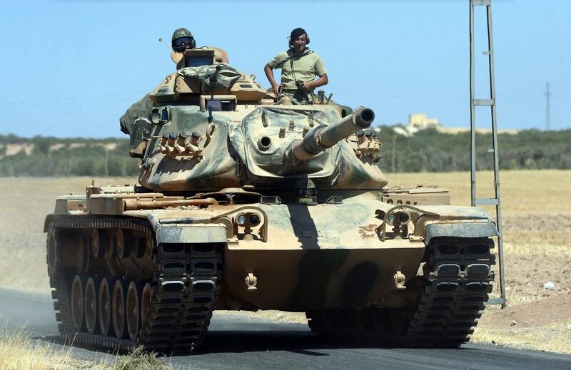 A Turkish tank heads towards the Syrian border, in Karkamis. Ismail Coskun / IHA via AP