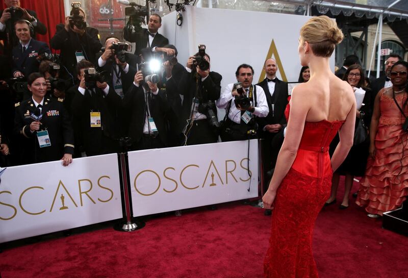 FILE - In this Feb. 22, 2015 file photo, actress Rosamund Pike arrives at the Oscars in Los Angeles. There are two paths on the Oscars red carpet: one for famous people, and one for everyone else. Stanchions and velvet ropes separate the recognizable from the not. Famous folks walk on the side of the carpet closest to the cameras and reporters, and stars often collide or share impromptu carpet greetings. (Photo by Matt Sayles/Invision/AP, File)