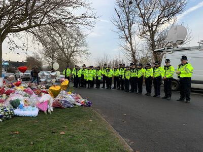 Twenty-one officers from West Midlands Police lay bouquets and stand in silence on Tuesday near the scene in Babbs Mill Park in Kingshurst, Solihull, after the boys' deaths. PA