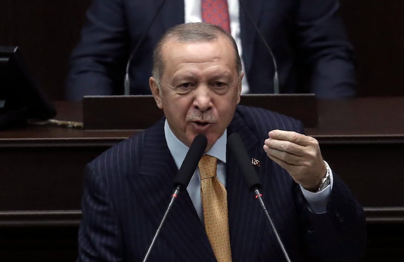 Turkey's President Recep Tayyip Erdogan addresses his ruling party lawmakers at the parliament, in Ankara, Turkey, Wednesday, Oct. 28, 2020. Turkish officials on Wednesday railed against French satirical magazine Charlie Hebdo over its cover-page cartoon mocking Turkish President Recep Tayyip Erdogan and accused it of sowing "the seeds of hatred and animosity." Tensions between France and Turkey have mounted in recent months over Turkish actions in Syria, Libya and the Caucasus Mountains region of Nagorno-Karabakh.(AP Photo)