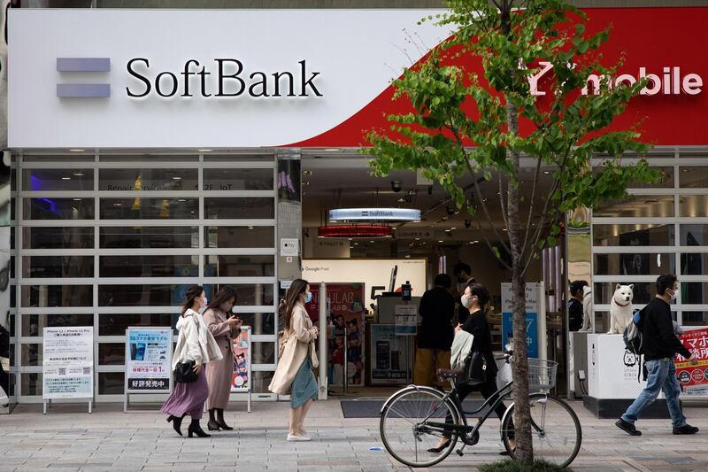Pedestrians walk past a SoftBank mobile shop in the Ginza shopping district in Tokyo on April 6, 2021.  / AFP / Yuki IWAMURA
