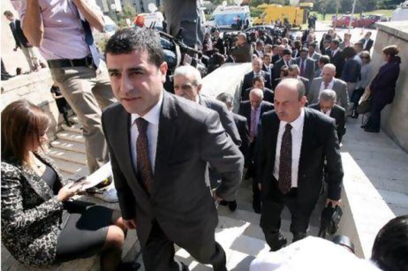 The newly elected MPs of the pro-Kurdish Peace and Democracy Party and its chairman, Selahattin Demirtas, (foreground) seen arriving outside the parliamentary building in Ankara as they ended a four-month boycott of the Turkish parliament. ADEM ALTAN / AFP PHOTO