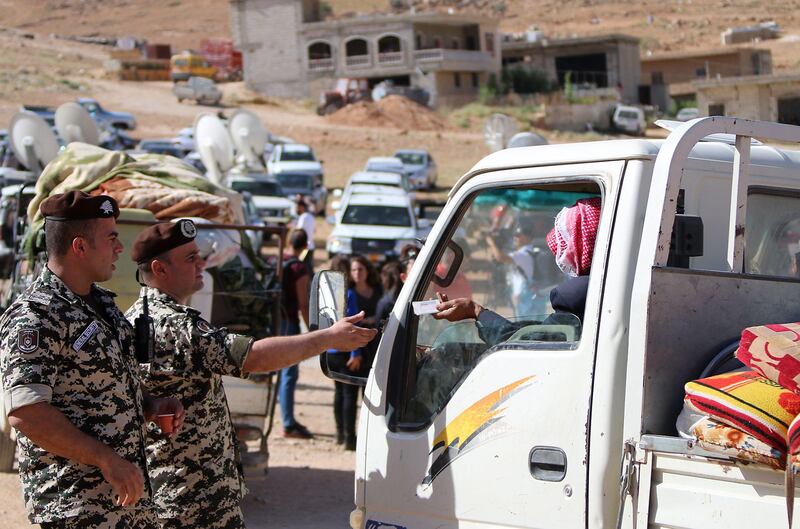 Lebanese security forces check identity and papers of Syrian refugees getting ready to cross into Syria from the eastern Lebanese border town of Arsal, on June 28, 2018. Stringer / AFP