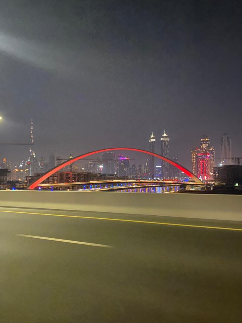 Tolerance Bridge at Dubai Water Canal glowing in the colour red. The National