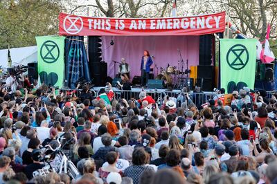 Swedish climate change activist Greta Thunberg (C) speaks at the Extinction Rebellion group's environmental protest camp at Marble Arch in London on April 21, 2019, on the seventh day of the group's protest calling for political change to combat climate change. Climate change protesters who have brought parts of London to a standstill said Sunday they were prepared to call a halt if the British government will discuss their demands. Some 831 arrests have been made and 42 people charged in connection with the ongoing Extinction Rebellion protests. On the seventh day of demonstrations that have occupied key spots in the British capital, organisers said they were willing to switch tactics from disruption to dialogue.
 / AFP / Tolga Akmen
