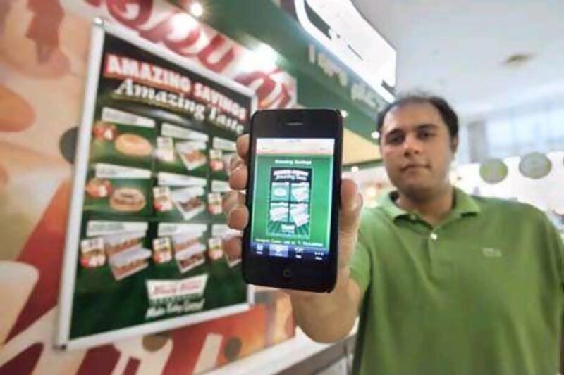 UAE - Dubai - March 02- 2011: Mihir Shan show his iphone with the ishopaholic application for Krispy Kreme at Ibn Batuta Mall. ( Jaime Puebla - The National Newspaper )