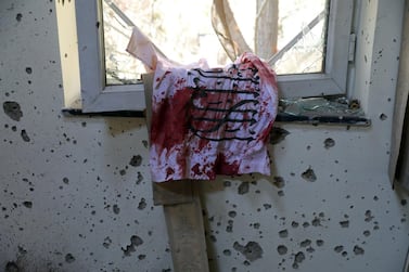 A blood-stained Taliban flag is seen on the window inside the Kabul University after a deadly attack in Kabul, Afghanistan, Tuesday, Nov. 3, 2020. The brazen attack by gunmen who stormed the university has left many dead and wounded in the Afghan capital. The assault sparked an hours-long gun battle. (AP Photo/Rahmat Gul)