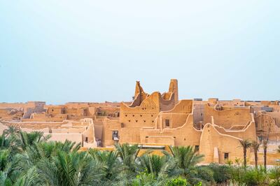 Silhouette of Salwa Palace in At-Turaif in Ad Diriyah with palm trees in foreground. Photo by THAMER AL AHMADI