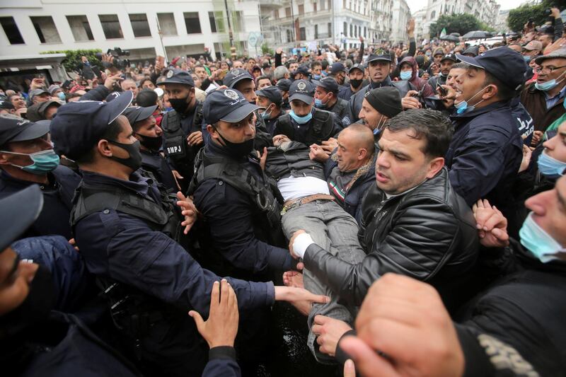A man is carried by police and protesters during a rally marking two years since the start of a mass protest movement demanding political change, in the Algerian capital, Algiers. Reuters