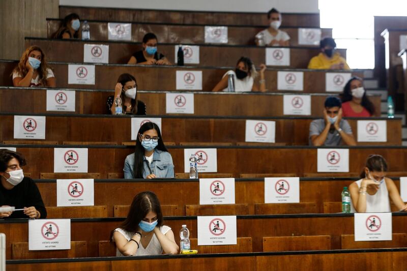 Students sit at a distance as a precaution against COVID-19, as they undergo an aptitude test to access the University of Medicine, in Rome. AP Photo