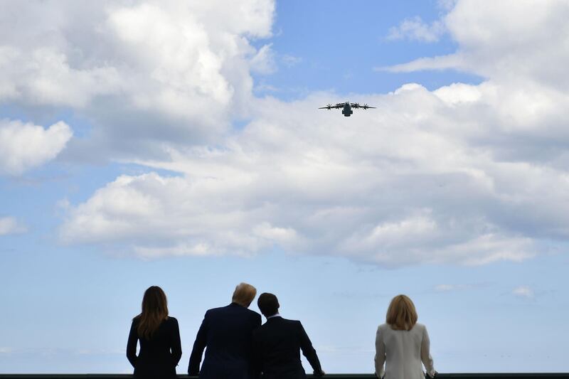 US First Lady Melania Trump, US President Donald Trump, French President Emmanuel Macron and French President's wife Brigitte Macron watch aircraft fly over in Colleville-sur-Mer, Normandy,France. AFP