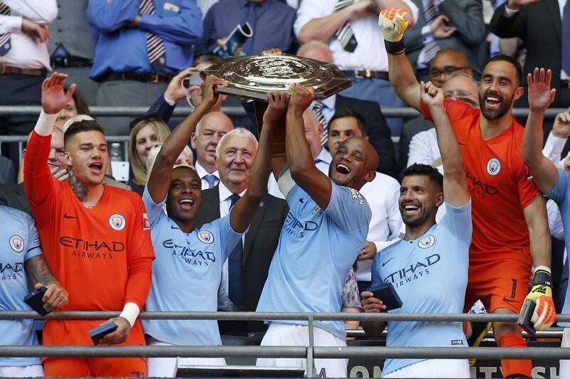 Manchester City's Belgian defender Vincent Kompany (centre right) and Manchester City's Brazilian midfielder Fernandinho (centre left) lift the FA Community Shield as Manchester City players celebrate their victory after the English FA Community Shield football match between Chelsea and Manchester City at Wembley Stadium in north London on August 5, 2018. - Manchester City won the game 2-0. (Photo by Ian KINGTON / AFP) / NOT FOR MARKETING OR ADVERTISING USE / RESTRICTED TO EDITORIAL USE