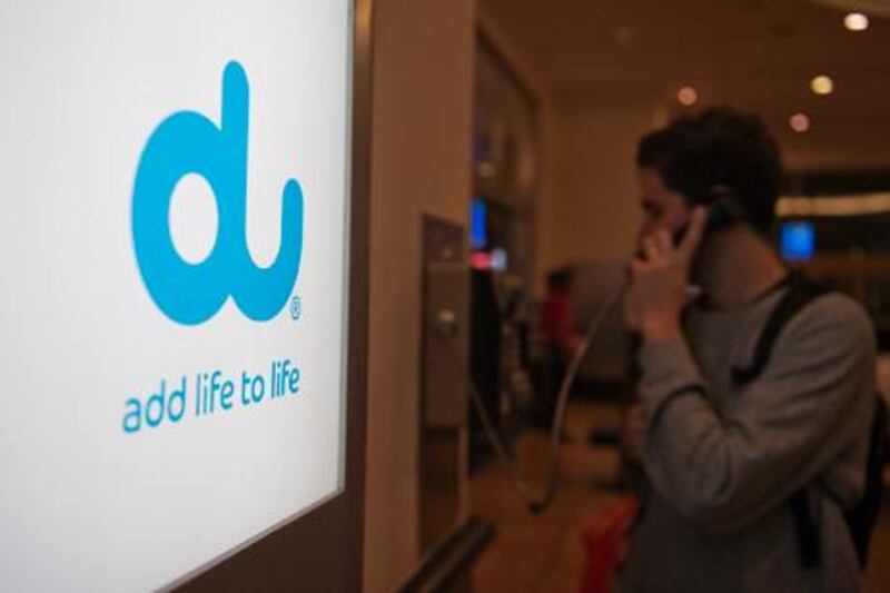 Dubai, United Arab Emirates - Dec 29, 2011 - A shopper uses a payphone next to a DU advertisement at Mall of the Emirates in Dubai. Sarah Dea / The National    