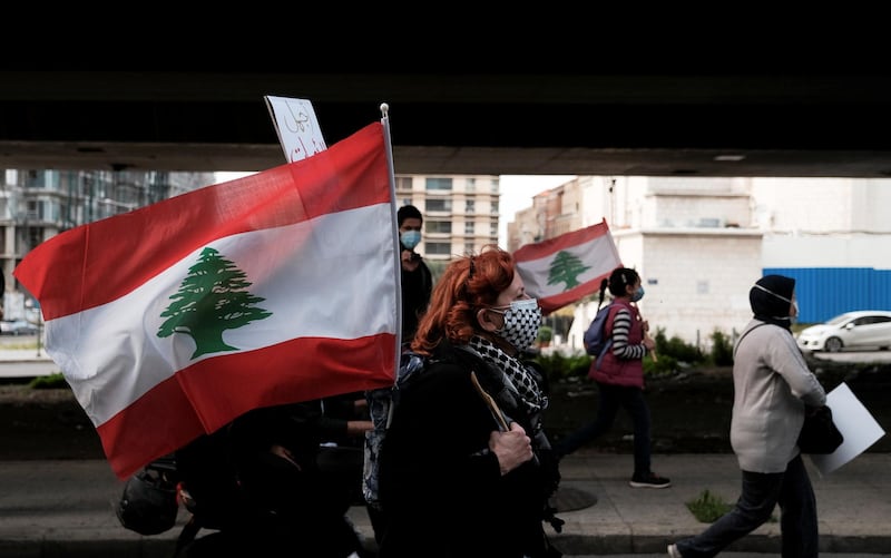 A Lebanese mother walks with a national flag as she takes part in a march against the political and economic situation, ahead of Mother's Day in Beirut, Lebanon. Reuters