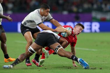 Josh Adams of Wales is tackled during the Rugby World Cup game against Fiji at the Oita Stadium. Getty