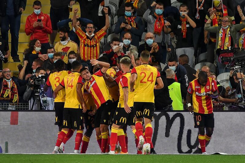 Lens' players celebrate after scoring their team's first goal against PSG. AFP