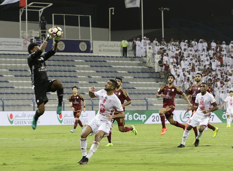 Rashed Ali Alsuwaidi, goalkeeper of Al Wahda, saves the ball as Shaheen Abdelrahman, number 4 of Sharjah, watches during the President Cup 2017 semi-final match. Jeffrey E Biteng / The National