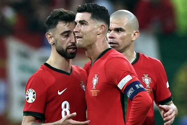Cristiano Ronaldo of Portugal (R) reacts with teammates Bruno Fernandes (L) and Pepe after failing to score by penalty during the UEFA EURO 2024 Round of 16 soccer match between Portugal and Slovenia, in Frankfurt Main, Germany, 01 July 2024.   EPA / ANNA SZILAGYI