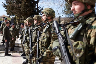Greece's Prime Minister Kyriakos Mitsotakis, left, reviews Greek soldiers guard at the Kipoi border gate, Evros region, at the Greek-Turkish border on Tuesday, March 3, 2020. Migrants and refugees hoping to enter Greece from Turkey appeared to be fanning out across a broader swathe of the roughly 200-kilometer-long land border Tuesday, maintaining pressure on the frontier after Ankara declared its borders with the European Union open. (Dimitris Papamitsos/Greek Prime Minister's Office via AP)