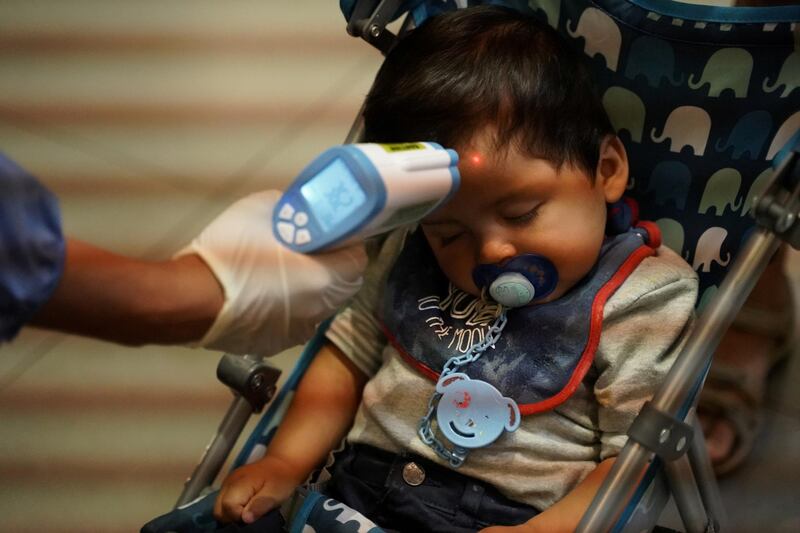 Francisco, 1, from Chile, sleeps inside his stroller while a health ministry official measures his body temperature inside El Dorado International Airport after flights were suspended to curb the spread of coronavirus disease (COVID-19), in Bogota, Colombia. REUTERS