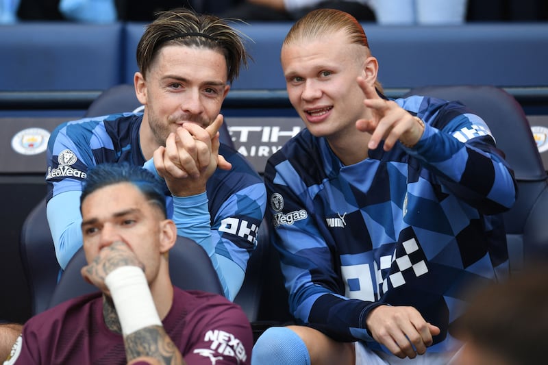 Jack Grealish, left, talks to Erling Haaland on the Manchester City bench. AFP