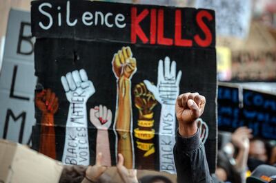 A demonstrator clenches his fist during a Black Lives Matter rally in Parliament Square in London, Saturday, June 6, 2020, as people protest against the killing of George Floyd by police officers in Minneapolis, USA. (AP Photo/Frank Augstein)