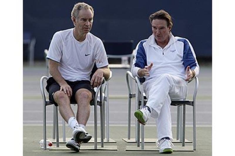 John McEnroe, left, and Jimmy Conners talk after hitting a few balls.