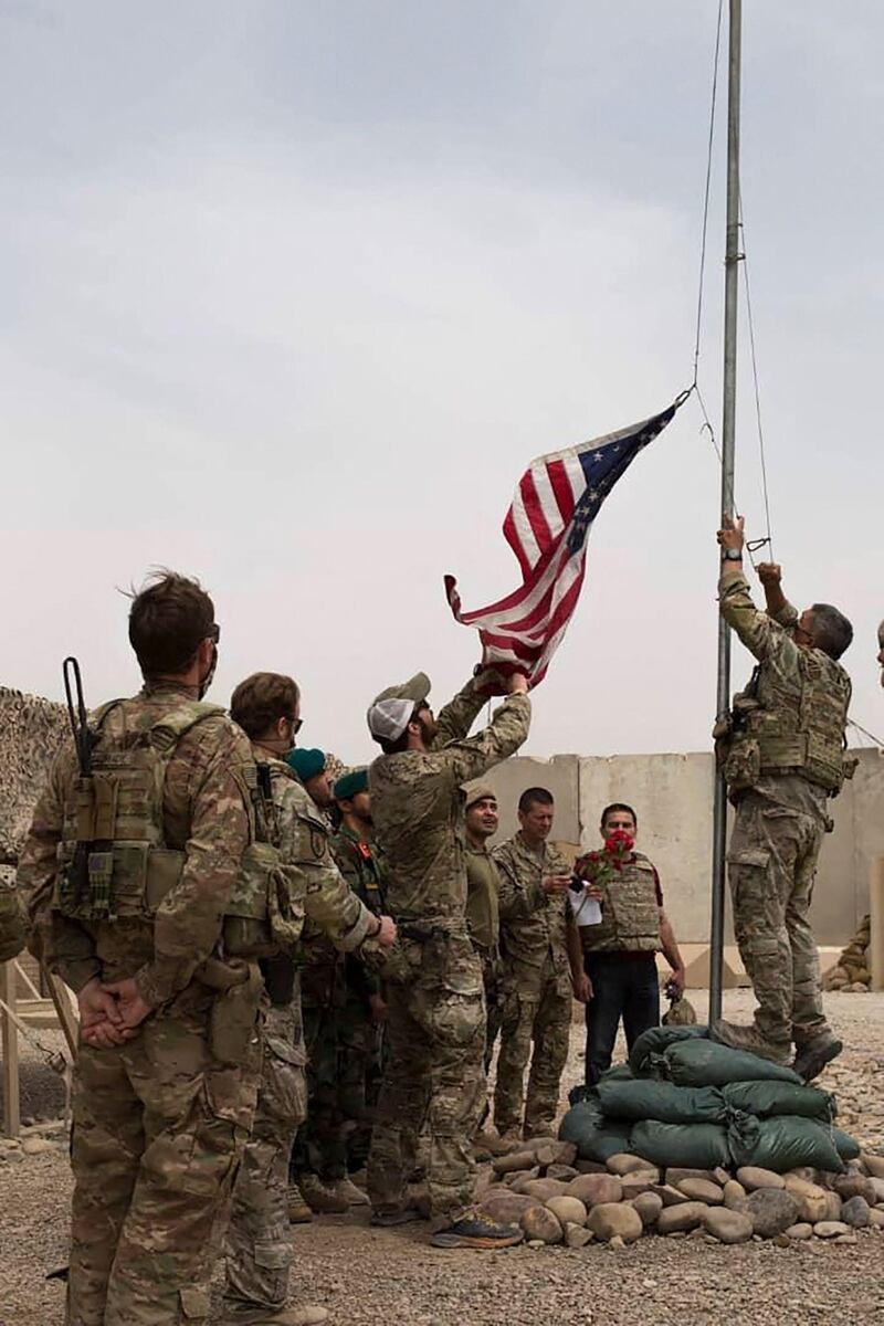 This handout photograph taken on May 2, 2021 and released by Afghanistan's Ministry of Defense shows US soldiers lowering the US national flag during a handover ceremony to the Afghan National Army (ANA) army 215 Maiwand corps at Antonik camp in Helmand province. RESTRICTED TO EDITORIAL USE - MANDATORY CREDIT "AFP PHOTO /Afghanistan's Ministry of Defense" - NO MARKETING - NO ADVERTISING CAMPAIGNS - DISTRIBUTED AS A SERVICE TO CLIENTS
 / AFP / Afghanistan's Ministry of Defence office / - / RESTRICTED TO EDITORIAL USE - MANDATORY CREDIT "AFP PHOTO /Afghanistan's Ministry of Defense" - NO MARKETING - NO ADVERTISING CAMPAIGNS - DISTRIBUTED AS A SERVICE TO CLIENTS
