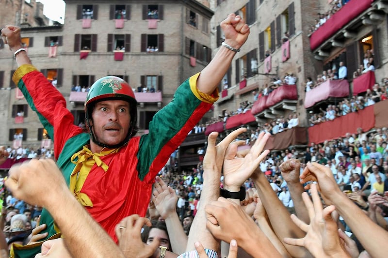 Andrea Mari, the winning jockey, celebrates with the crowd. Vincenzo Pinto / AFP