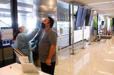 A traveler receives an in-airport Covid-19 nasal swab test a day before his flight to Hawaii during the Covid-19 pandemic at Los Angeles International Airport (LAX) in Los Angeles, California, November 18, 2020. / AFP / Patrick FALLON
