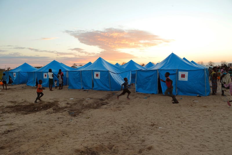 Women and children are outside a displacement camp in Beira, Mozambique, Sunday, March, 31, 2019. Mozambican authorities say the number of cholera cases among cyclone survivors has risen to 271. The cases have been discovered in the port city of Beira, raising the stakes in an already desperate fight to help hundreds of thousands of people sheltering in increasingly squalid conditions.(AP Photo/Tsvangirayi Mukwazhi)