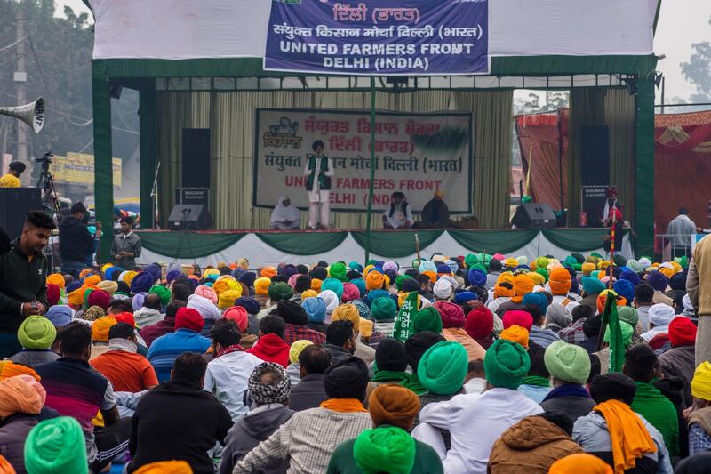 NEW DELHI, INDIA - DECEMBER 11: Indian farmers listen  to speaker as they sit in a protest against the new farm laws on December 11, 2020 at the Delhi-Haryana state border, India. Braving cold temperatures, thousands of farmers, mostly from the Indian states of Punjab, Haryana and Uttar Pradesh, are camping for the past two weeks on the peripheries of India's national capital to protest three agricultural laws which they allege have been passed by the Narendara Modi-led government to benefit large corporates. Unions representing the farmers have rejected the governments draft proposal to amend the laws, while moving the country's apex court for their repeal and announcing an intensified stir which includes blocking of major highways leading to the capital New Delhi  and a nationwide shutdown until their demands are met. (Photo by Yawar Nazir/Getty Images)