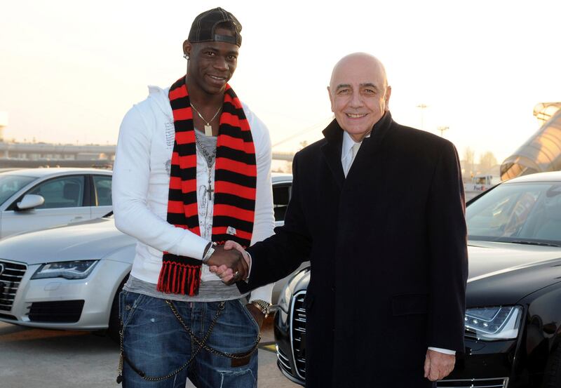 Mario Balotelli, left, shakes hands with AC Milan vice president Adriano Galliani upon his arrival at the Milan Malpensa airport, Italy, Wednesday, Jan. 30,  2013. Italy striker Mario Balotelli landed in Milan to finalize his move from Manchester City to AC Milan on Wednesday. Milan announced on Tuesday that it reached an agreement with City and that Balotelli would sign a 4 1/2-year deal following a medical exam. "It's been a long time that I've wanted to play for Milan, but obviously I was playing for other clubs so I couldn't come here," Balotelli said, wearing a Milan scarf around his neck. "Now I had the opportunity and I ran." (AP Photo/Studio Buzzi) *** Local Caption ***  Italy Soccer AC Milan Balotelli.JPEG-0b3a2.jpg