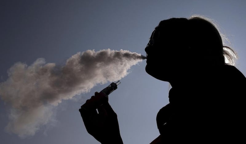 A woman exhales vapour from an e-cigarette. A UK study has shown that certain flavoured liquids used in vaping contain chemicals which could damage fertility. Phil Noble / Reuters