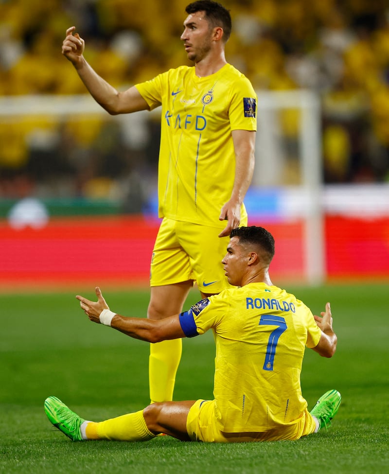 Al Nassr's Cristiano Ronaldo and Aymeric Laporte react. Reuters