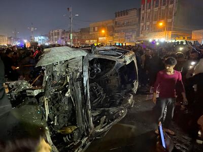 Iraqis gather at the site of the vehicle that was hit by the US strike in east Baghdad. AP Photo