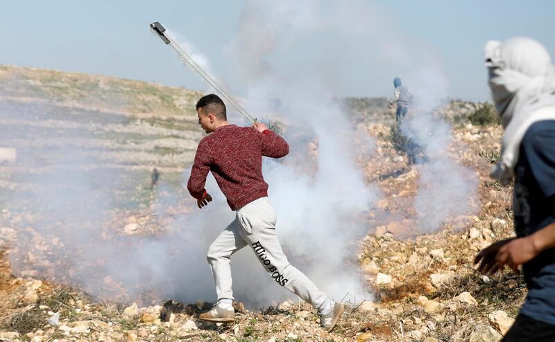 Palestinian demonstrators returns a tear gas canister fired by Israeli troops during a protest in the village of Aboud near Ramallah in the Israeli-occupied West Bank. Reuters