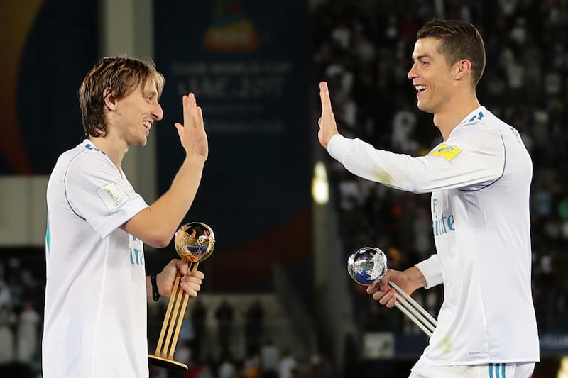Real Madrid's Portuguese forward Cristiano Ronaldo (R) holding his 2017 FIFA Club World Cup Silver Ball award celebrates with his teammate Luka Modric holding his 2017 FIFA Club World Cup gold award after winning the FIFA Club World Cup final football match against Gremio FBPA at the Zayed Sports City Stadium in Abu Dhabi on December 16, 2017.
Real Madrid defeated Gremio 1-0 to lift the FIFA Club World Cup for the third time. / AFP PHOTO / KARIM SAHIB