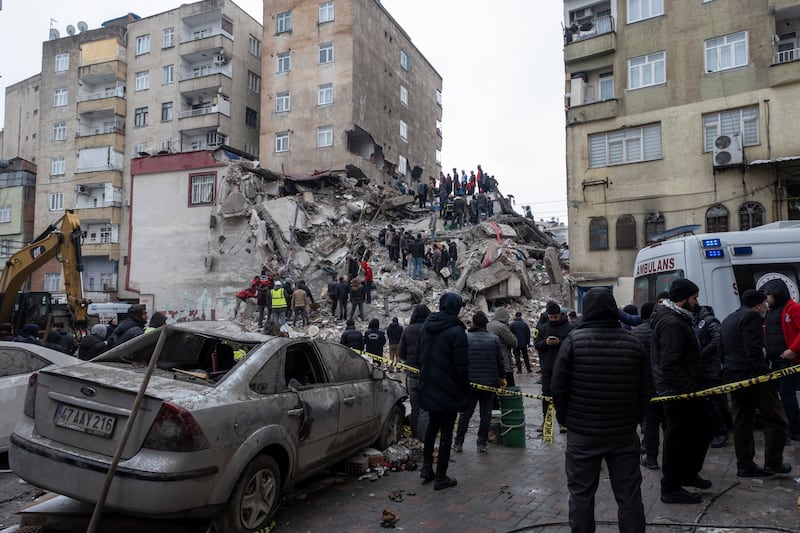 Emergency personnel search for victims at the site of a collapsed building in Diyarbakir, south-east Turkey, on Monday. EPA