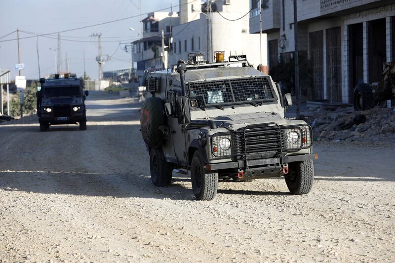 epa07765409 Israeli army vehicles at a street in the West Bank village of Beit Kahil, 10 August 2019. According to reports, four suspects, three Palestinian men and a woman from the Palestinian village of Beit Kahil, have been taken into custody after Israeli security forces raided the village as part of a manhunt for the killers of 18-year-old Israeli soldier Dvir Sorek, who was found stabbed to death two days earlier in the Gush Etzion settlement.  EPA/ABED AL HASHLAMOUN