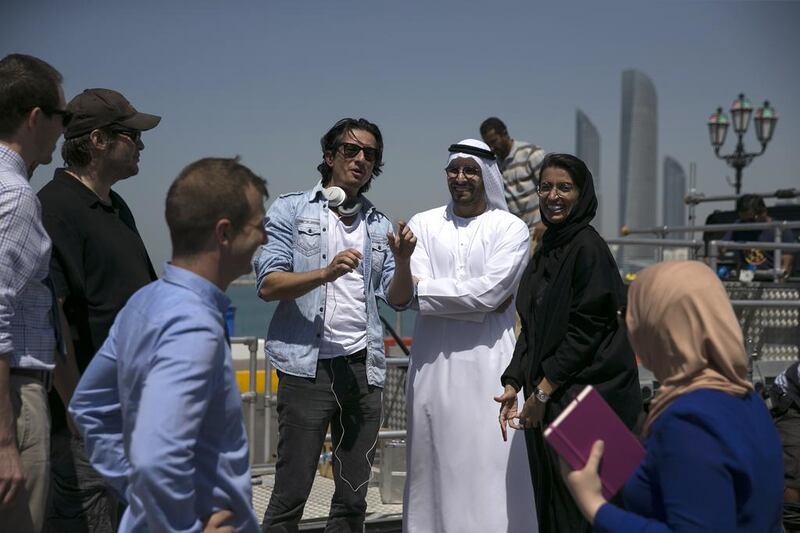 Emirati filmmaker Ali Mostafa talks with Mohamed Al Mubarak, Chairman of Image Nation, and Noura Al Kaabi, Chief Executive Officer of twofour54 and a member of the UAE's Federal National Council as they visit on the set of Ali Mostafa. Silvia Razgova / The National