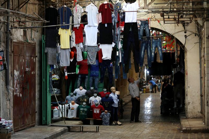 epa06171229 A Palestinian man opens his clothes shop ahead of the Eid al-Adha festival, in the West Bank city of Nablus, 30 August 2017. Eid al-Adha is the holiest of the two Muslims holidays celebrated each year, it marks the yearly Muslim pilgrimage (Hajj) to visit Mecca, the holiest place in Islam. Muslims slaughter a sacrificial animal and split the meat into three parts, one for the family, one for friends and relatives, and one for the poor and needy.  EPA/ALAA BADARNEH